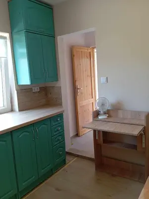 an empty kitchen with green cabinets and a counter at Blisko Energylandii in Zator