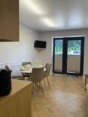 a kitchen and dining room with a table and chairs at Apartamenty 91 in Spytkowice