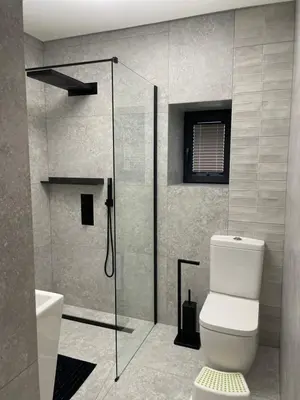 a bathroom with a toilet and a glass shower at Apartamenty 91 in Spytkowice