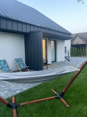 a hammock on the grass in front of a house at Apartamenty 91 in Spytkowice