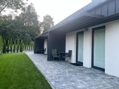 a patio with a table and chairs next to a house at Apartamenty 91 in Spytkowice