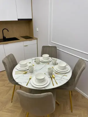 a dining room table with plates and cups and chairs at Apartamenty 91 in Spytkowice