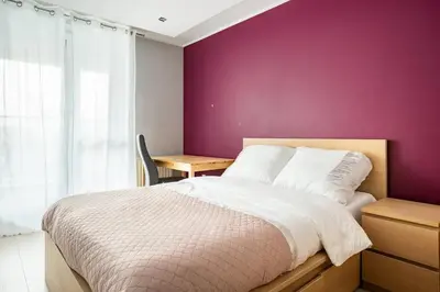 a bedroom with a purple wall and a bed and a desk at Apartament z widokiem na Wisłę in Kraków