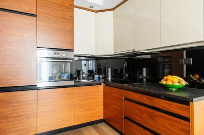 a kitchen with wooden cabinets and a bowl of fruit at Apartament z widokiem na Wisłę in Kraków