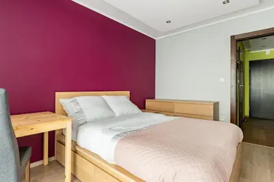 a bedroom with a bed and a purple wall at Apartament z widokiem na Wisłę in Kraków