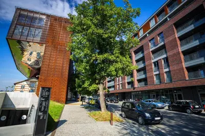 a car parked next to a building with a tree at Apartament z widokiem na Wisłę in Kraków