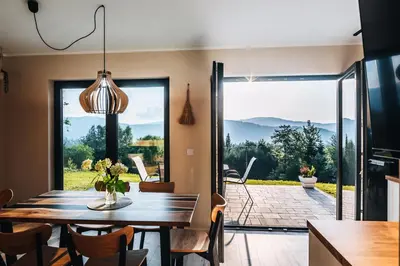 a dining room with a table and a large sliding glass door at Zawoja House in Zawoja