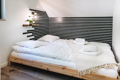 a bedroom with a large bed with white sheets and pillows at Zawoja House in Zawoja
