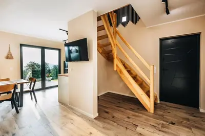 a living room with a dining room table and a staircase at Zawoja House in Zawoja