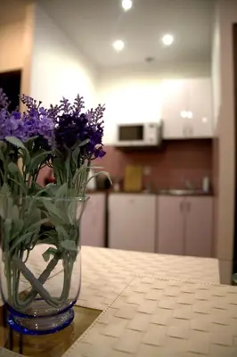 a vase of purple flowers sitting on a table at Apartamenty Astur in Kraków