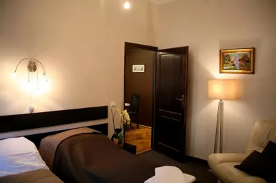 a bedroom with a bed and a lamp and a couch at Apartamenty Astur in Kraków
