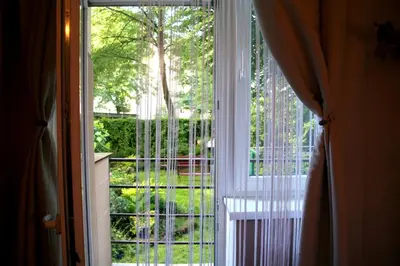 an open window with a view of a garden at Apartamenty Astur in Kraków