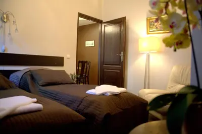 a bedroom with two beds and a lamp and a chair at Apartamenty Astur in Kraków