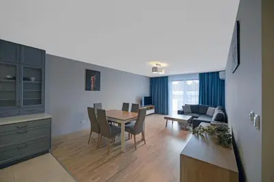 a kitchen and living room with a table and chairs at Apartament Jana 14 z garażem podziemnym in Bochnia