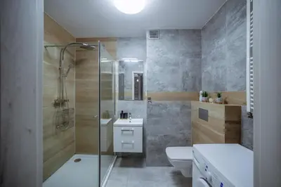 a bathroom with a shower and a toilet and a sink at Apartament Jana 14 z garażem podziemnym in Bochnia