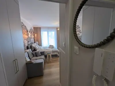 a hallway with a mirror and a living room at Bagry Lake Apartment in Kraków