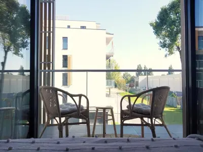 two chairs and a table in front of a window at Bagry Lake Apartment in Kraków