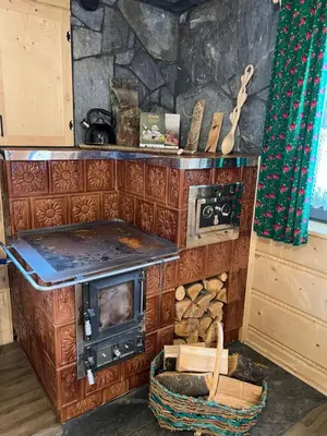 a wooden cabin with a table and benches at Górska Osada Śleboda in Zasadne