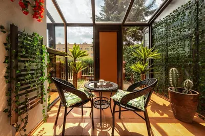 a patio with chairs and a table in a conservatory at Apartament PARYSKI 4 pokoje 90m2 2 poziomy Ogród Oranżeria in Kraków