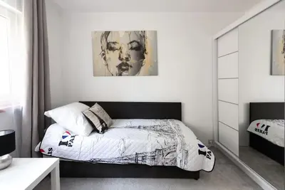 a bedroom with a bed and a painting on the wall at Apartament PARYSKI 4 pokoje 90m2 2 poziomy Ogród Oranżeria in Kraków