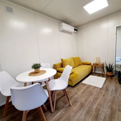 a living room with a couch and a table and chairs at Domki w Zatorze in Zator