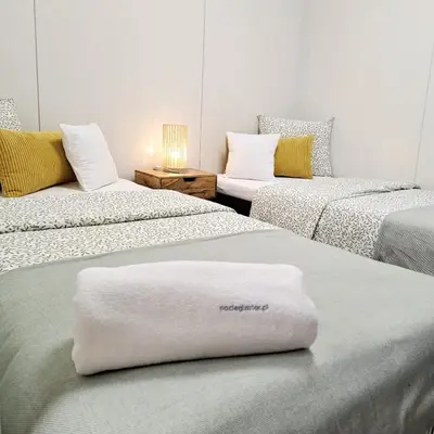 a yellow couch with a stack of towels on it at Domki w Zatorze in Zator