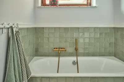 a bath tub in a bathroom with a green towel at Blisko in Wieprz