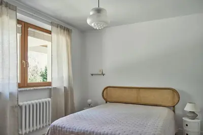 a white bedroom with a bed and a window at Blisko in Wieprz