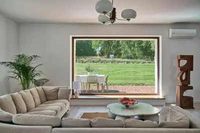 a living room with a couch and a large window at Blisko in Wieprz