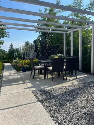 a patio with a table and chairs under a pergola at Dziupla in Wygiełzów