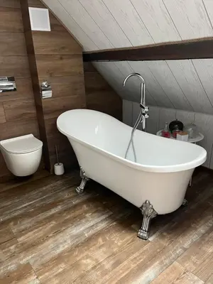 a white bath tub in a bathroom with a toilet at Dziupla in Wygiełzów