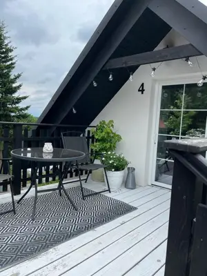 a patio with a table and chairs on a deck at Dziupla in Wygiełzów