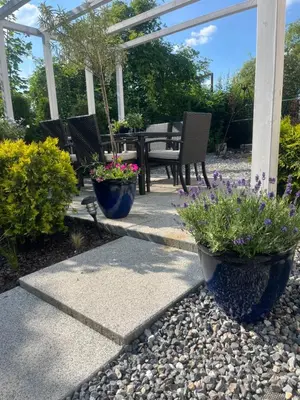 a patio with flowers and a table and chairs at Dziupla in Wygiełzów