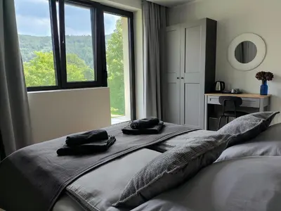a bedroom with a bed with two black towels on it at Heima in Zawoja
