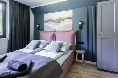 a bedroom with a large bed with a pink headboard at Heima in Zawoja