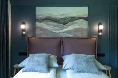 a bedroom with two beds and a painting on the wall at Heima in Zawoja
