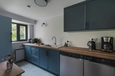 a kitchen with blue cabinets and a sink at Heima in Zawoja