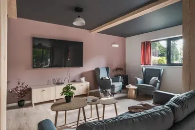 a living room with a couch and chairs and a tv at Heima in Zawoja