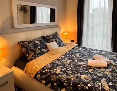 a bedroom with a bed with a blanket and pillows at Cracow Stay Premium Apartments FREE PARKING - 3 x ROOM - 3 x AIRCONDITION in Kraków
