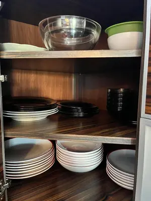 a cupboard filled with plates and bowls and dishes at Cracow Stay Premium Apartments FREE PARKING - 3 x ROOM - 3 x AIRCONDITION in Kraków
