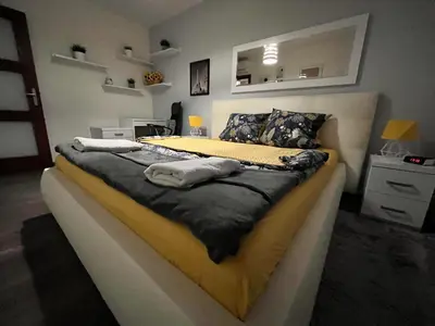 a bedroom with a large bed with a yellow and black blanket at Cracow Stay Premium Apartments FREE PARKING - 3 x ROOM - 3 x AIRCONDITION in Kraków