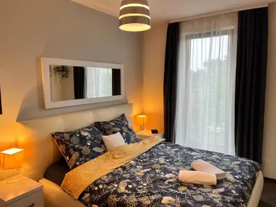 a bedroom with a bed and a window at Cracow Stay Premium Apartments FREE PARKING - 3 x ROOM - 3 x AIRCONDITION in Kraków