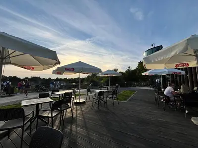 a group of tables and chairs with umbrellas on a deck at Cracow Stay Premium Apartments FREE PARKING - 3 x ROOM - 3 x AIRCONDITION in Kraków