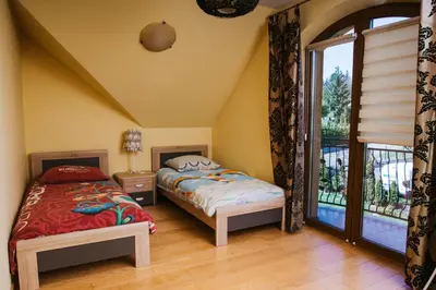 a bedroom with two beds and a balcony at Zagornik in Inwałd