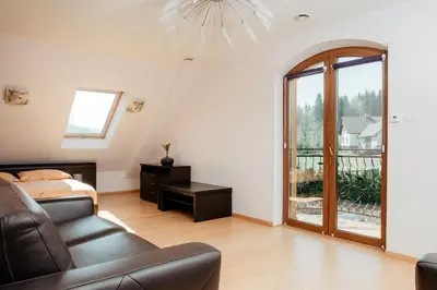 a bedroom with a couch and a bed and a window at Zagornik in Inwałd