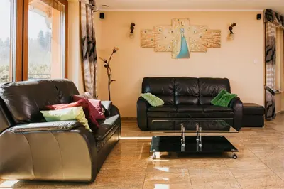 a living room with two leather couches and a table at Zagornik in Inwałd