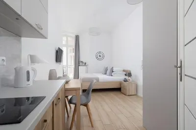 a white kitchen with a bed in a room at Studio apartment with balcony - Starowiślna 41 in Kraków
