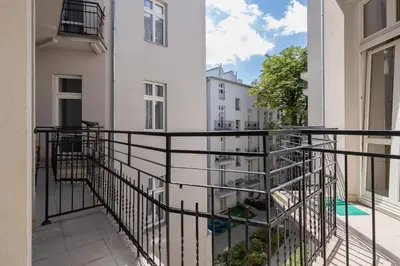 a balcony with a black railing next to a white building at Studio apartment with balcony - Starowiślna 41 in Kraków