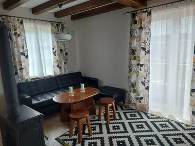 a living room with a couch and a table and chairs at WhyDeer in Wola Radziszowska