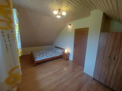an empty room with a bed and a light at WhyDeer in Wola Radziszowska